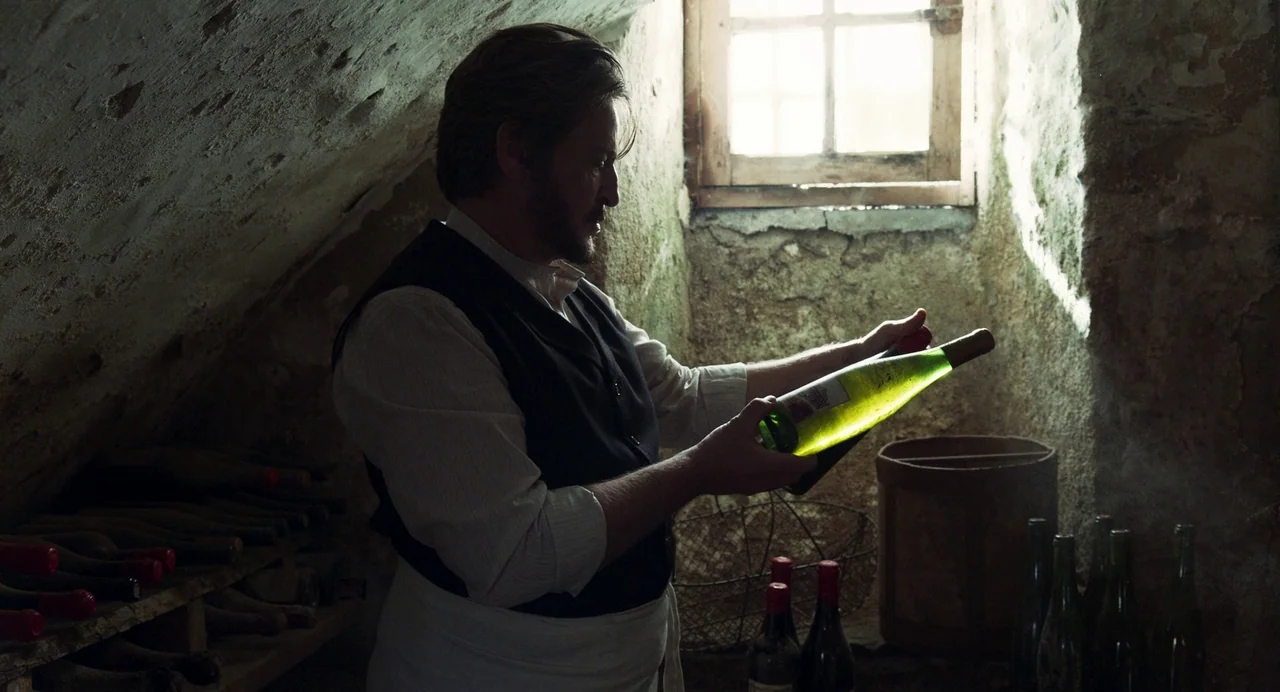The Taste of Things (2023) movie still: medium — An underground stone cellar with a small, rectangular window allowing daylight into the space. A…