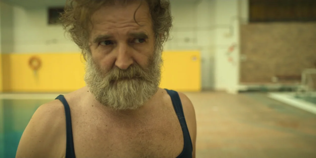 The Three Wise Men: The Truth (2022) movie still: medium — An indoor swimming pool features a large yellow wall and tiled floor surfaces. An older…