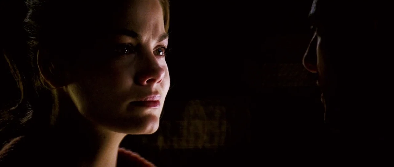 Down With Love (2003) movie still: closeup — A dark, unidentifiable interior setting features two people in low light. A woman faces a man whose…