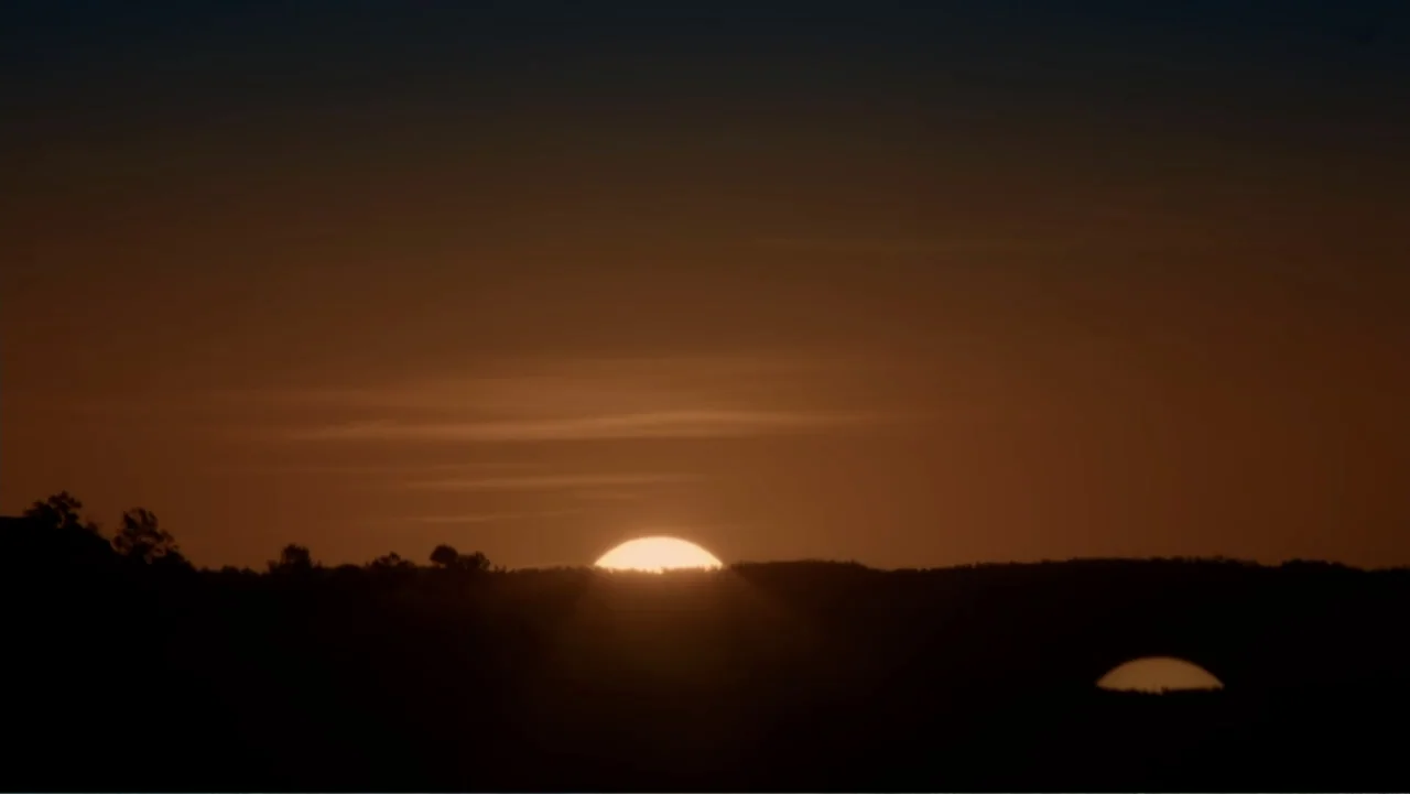 Alien Abduction: Betty and Barney Hill (2022) movie still: establishing — A vast outdoor landscape features a dark mountain silhouette against a…