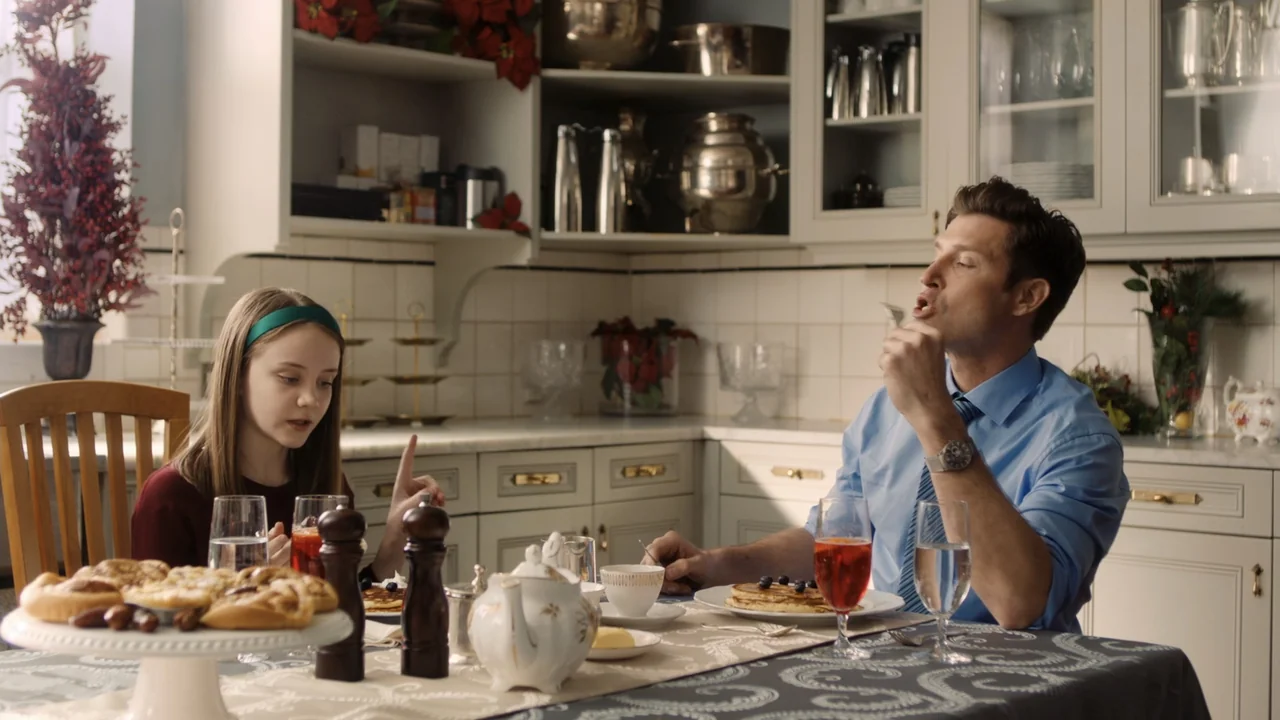 Christmas in Washington (2003) movie still: medium — A light-toned home dining area features a table laden with breakfast food and tea. A man and a…