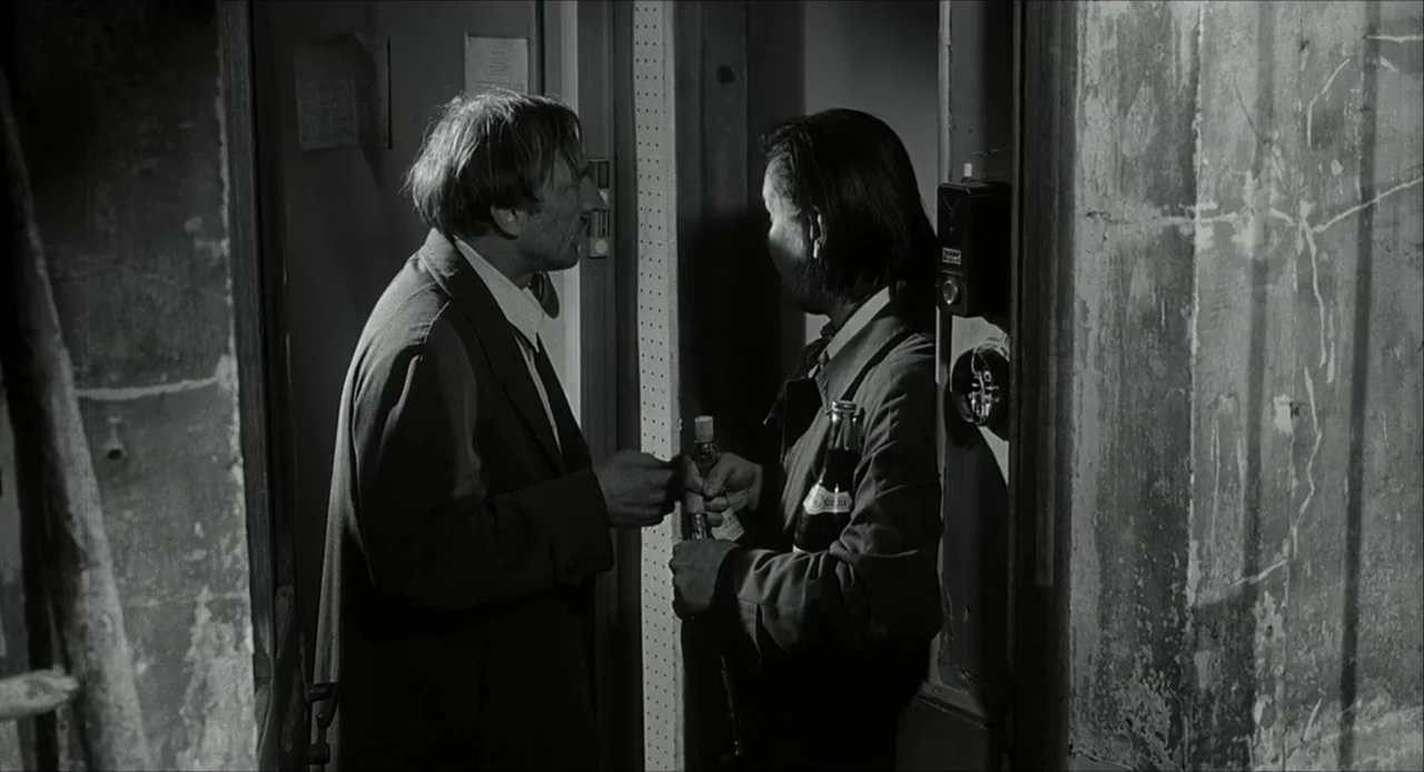 The Bohemian Life (1945) movie still: medium — A narrow, dimly lit hallway with weathered walls features peeling paint and exposed hardware. A man…