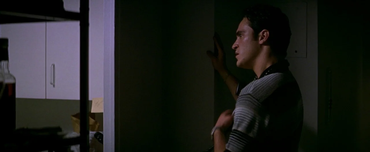 The Yards (2000) movie still: medium — An interior space features white cabinets in the background behind a dark doorway. A young man stands in…