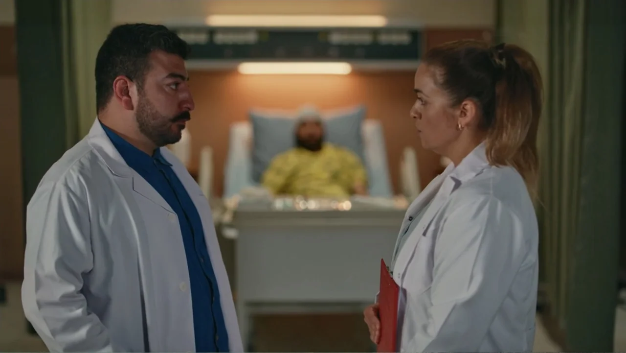 Paranormal Cuma (2024) movie still: medium — A hospital room contains two medical professionals in the foreground and a patient blurred behind. The…