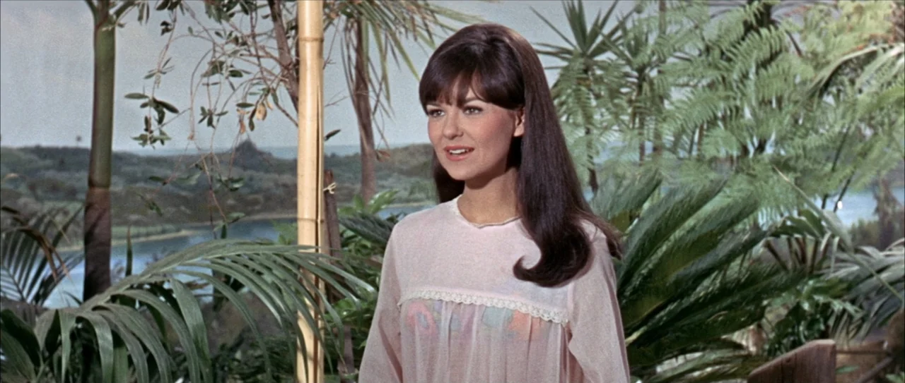 Clambake (1967) movie still: medium — A lush tropical terrace overlooks a distant river or bay under a bright sky. A woman stands in the foreground,…