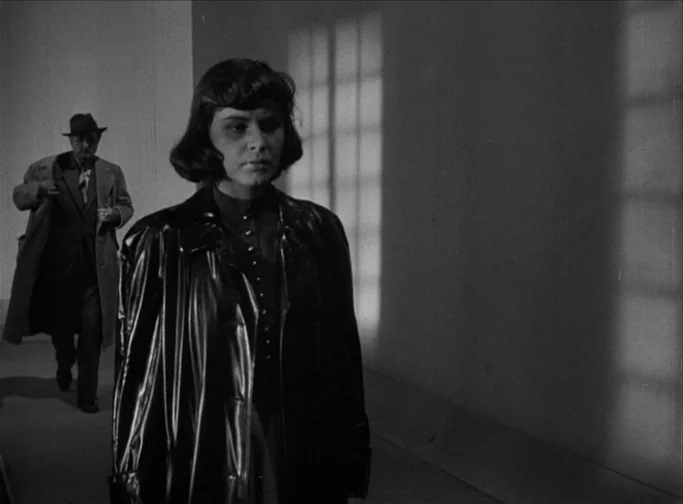 Summer Interlude (1951) movie still: medium — A dimly lit indoor hallway features high-contrast shadows cast by a window frame. A woman in a dark…