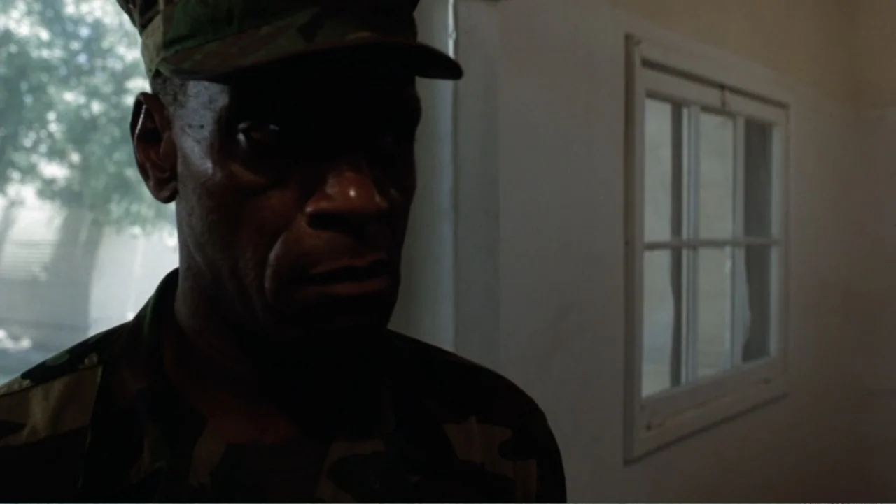 Heartbreak Ridge (1986) movie still: closeup — A dimly lit room with plain walls features a window looking out onto greenery. An older man in…