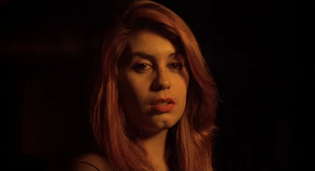 The Crossing Guard (1995) movie still: closeup — The subject stands in an entirely dark, indeterminate interior space. The woman stares toward the…