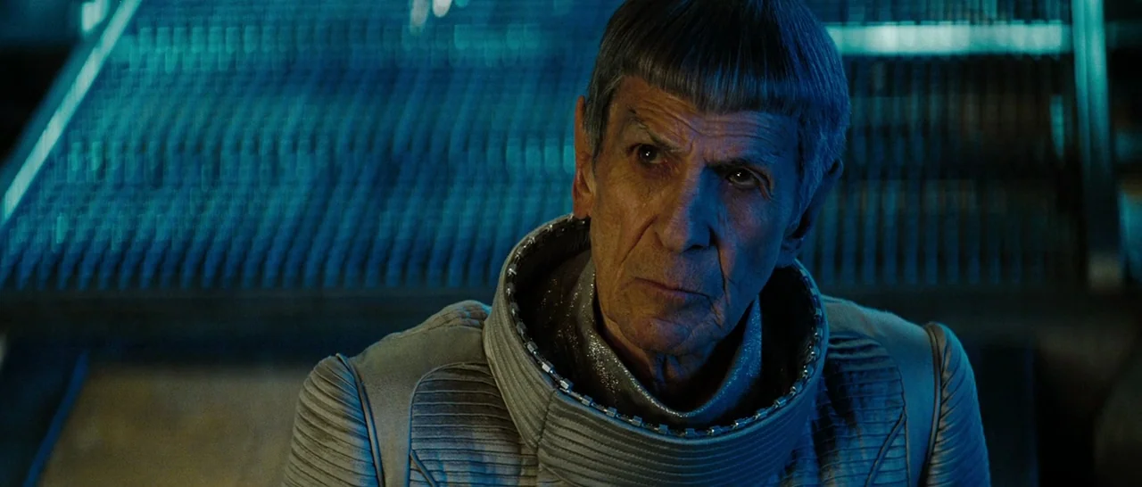 Star Trek (2009) movie still: closeup — An interior shot of a futuristic control room with metallic panels and deep blue lighting. An elderly man…