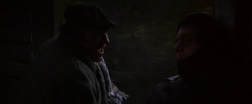 Scarecrow (1973) movie still: medium — A dark, cramped interior of a public transit vehicle during night travel. One man yells at another who sits…
