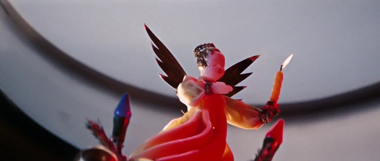 On Her Majesty’s Secret Service (1969) movie still: closeup — A close-up shot of a small angel figurine perched atop a decorative structure. The…