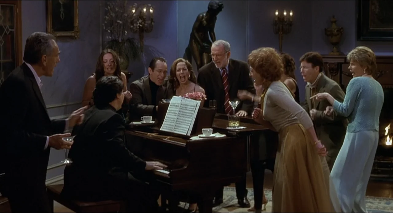 Scary Movie 2 (2001) movie still: medium — An elegant living room features a grand piano surrounded by people in formal evening attire. The guests…