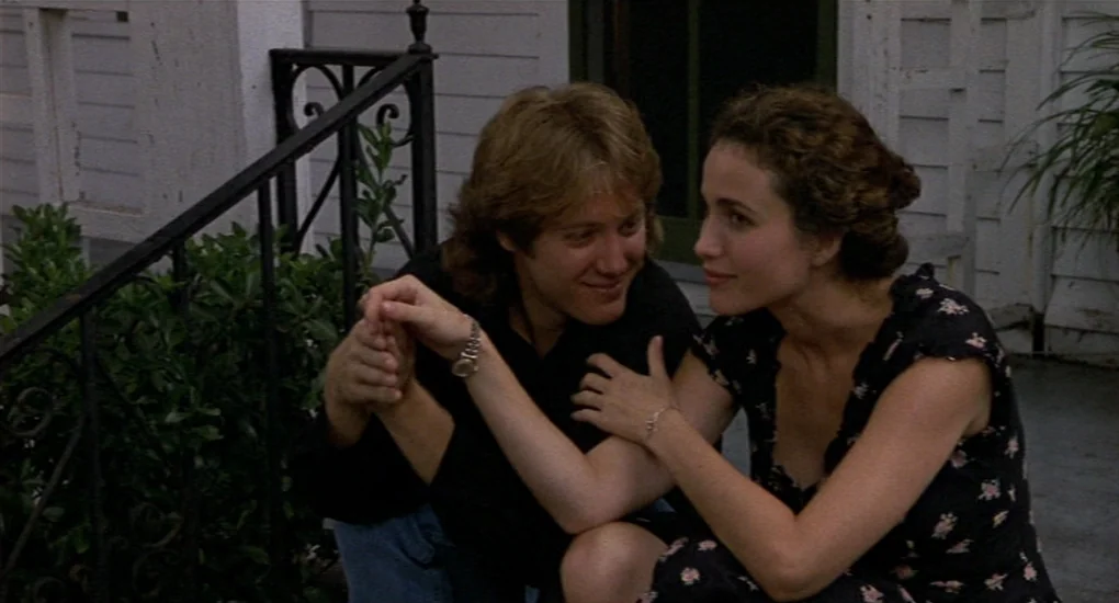 Sex, Lies And Videotape movie still: medium — A wooden porch with black wrought iron railings and white siding in the background. A man and a woman…
