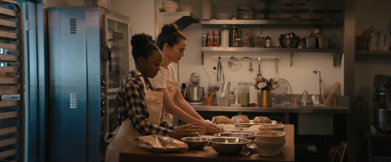 Something from Tiffany's (2022) movie still: medium — A professional bakery kitchen features stainless steel equipment, shelves with various…
