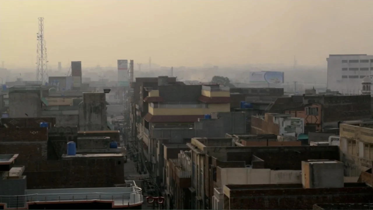 A Girl in the River: The Price of Forgiveness (2015) movie still: establishing — A dense urban expanse of flat-roofed concrete buildings stretches…