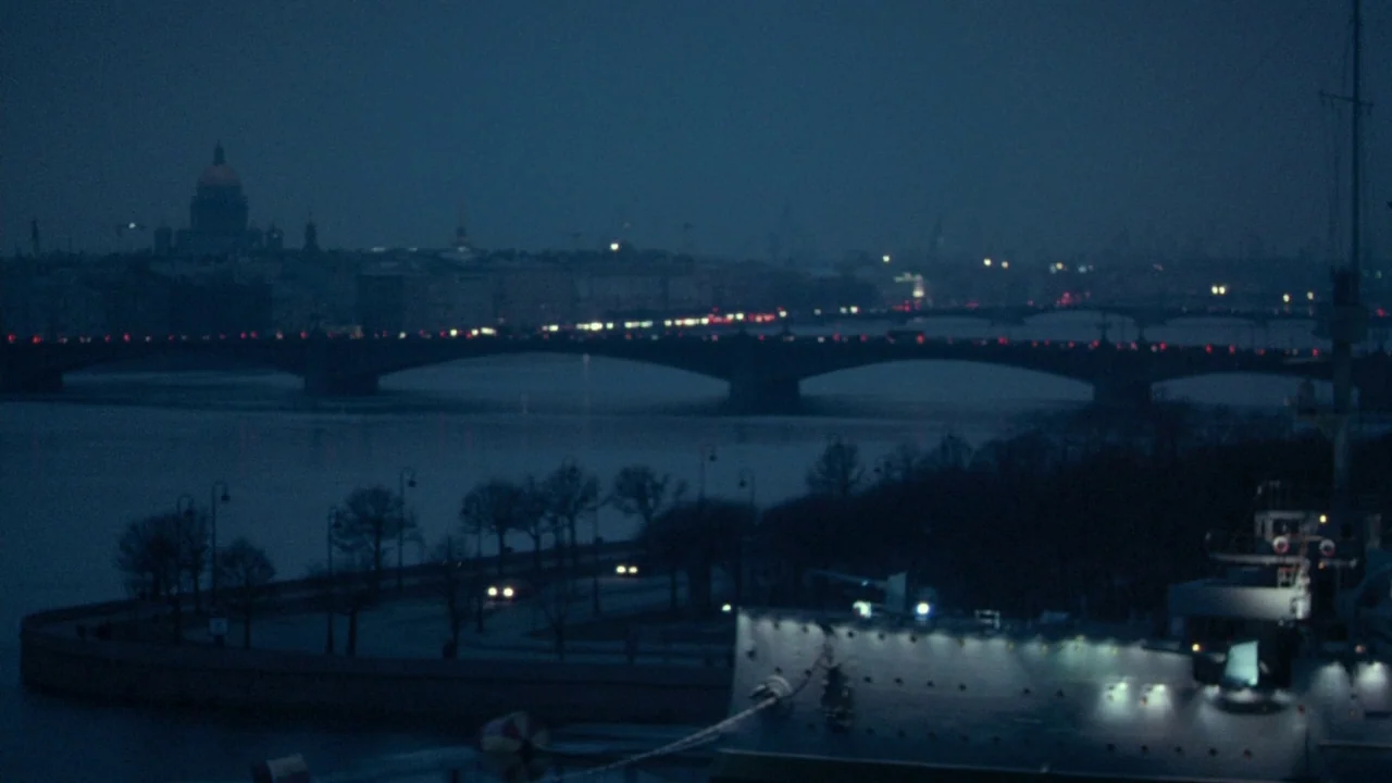 Cold Souls (2009) movie still: establishing — A wide dark river flows past a stone embankment with leafless trees at night. A large naval vessel…