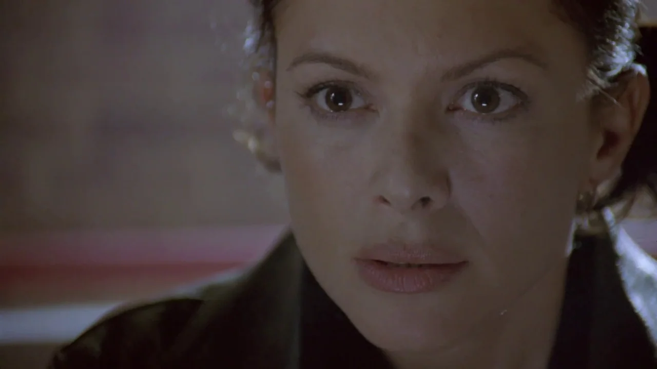 Hellraiser: Deader (2005) movie still: closeup — A close-up shot focuses on a woman's face against a neutral, out-of-focus background. She looks…