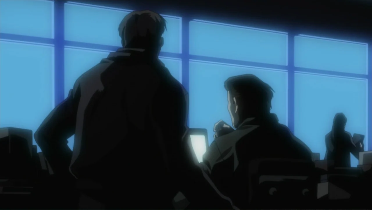 Batman: Gotham Knight (2008) movie still: medium — A dark office at night features large grid-pattern windows overlooking a dim city exterior. Two…