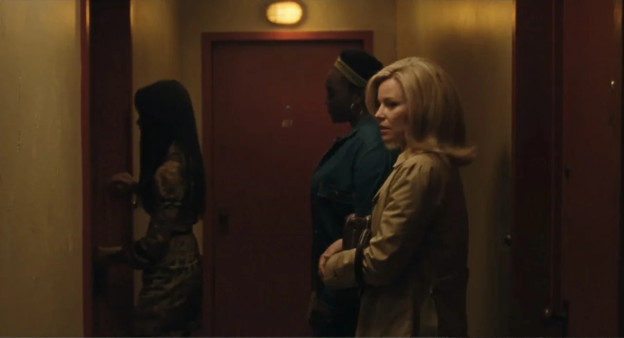 Call Jane (2022) movie still: medium — A dimly lit narrow apartment hallway features painted walls and a single ceiling light. Three women in period…