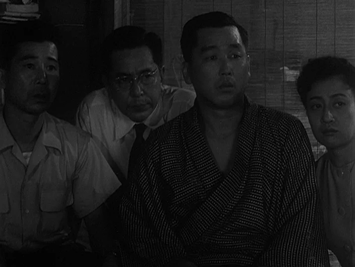 I Live In Fear (1955) movie still: medium — Four people sit closely together inside a room with a bamboo screen background. They are positioned…