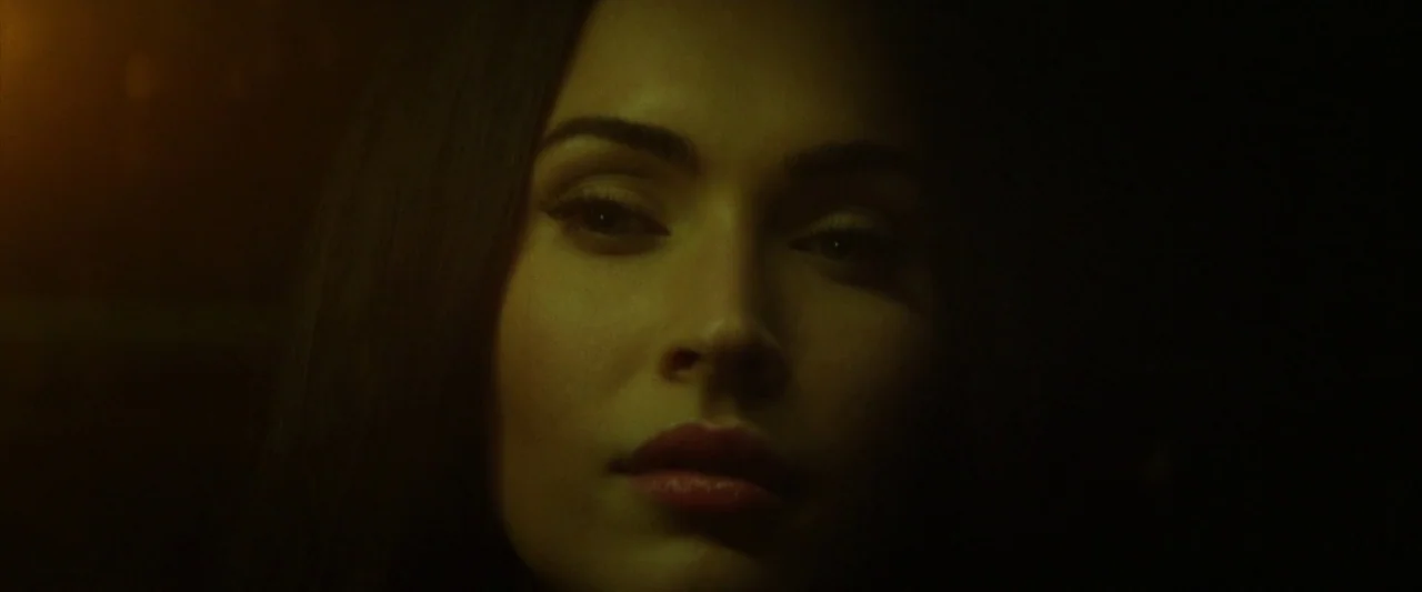 Zeroville (2019) movie still: closeup — A dark, dimly lit environment where only the subject's face is visible. A woman with dark hair stares…