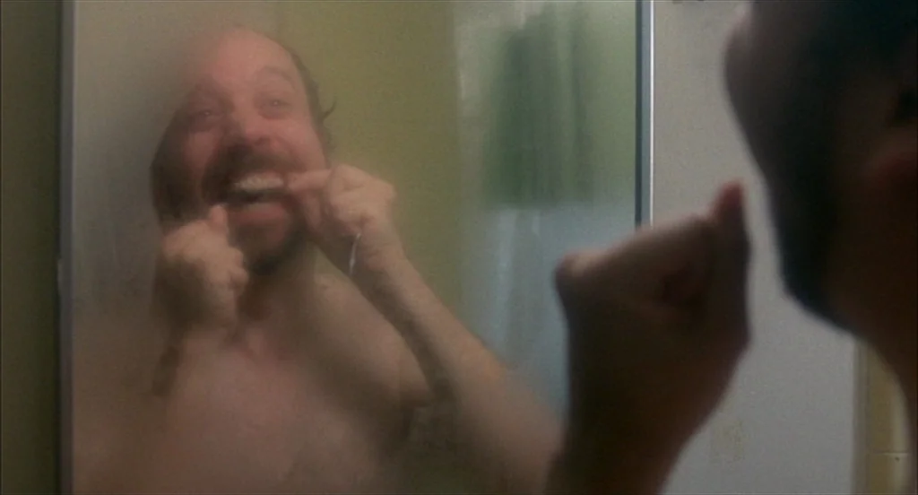 Sideways (2004) movie still: closeup — A man looks into a bathroom mirror that is partially obscured by moisture. He holds a piece of dental floss…