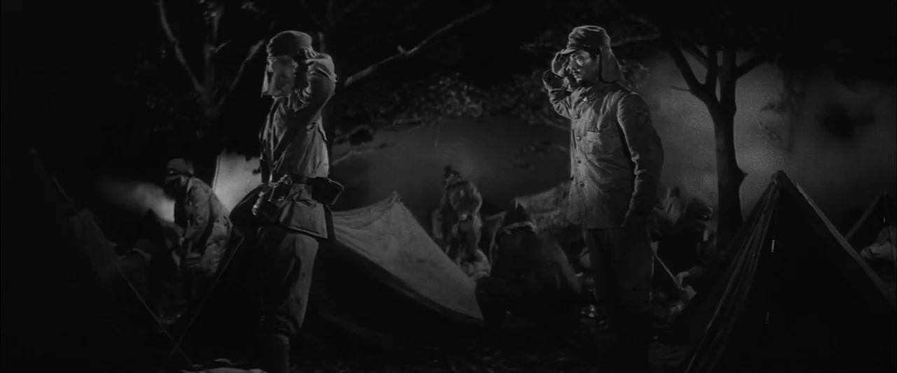 The Human Condition II: Road to Eternity (1959) movie still: wide — A military campsite at night features several canvas tents arranged under dark…
