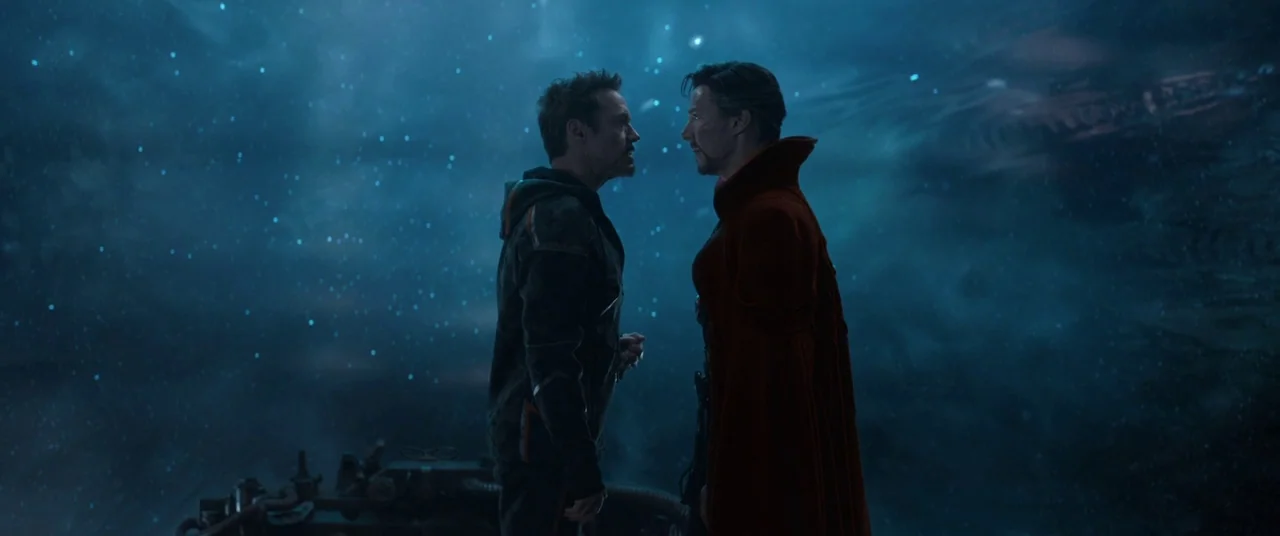 Avengers: Infinity War (2018) movie still: medium — Two men stand close together facing one another in a dark, star-lit space environment. They…