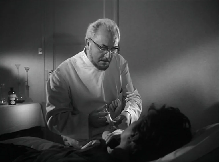 Head Against The Wall (1959) movie still: medium — A sparsely furnished medical setting with a small table featuring glass medical vials. A doctor…