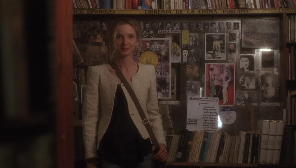 Before Sunset (2004) movie still: medium — A cramped retail space with shelves overflowing with books and walls covered in flyers. A woman with…