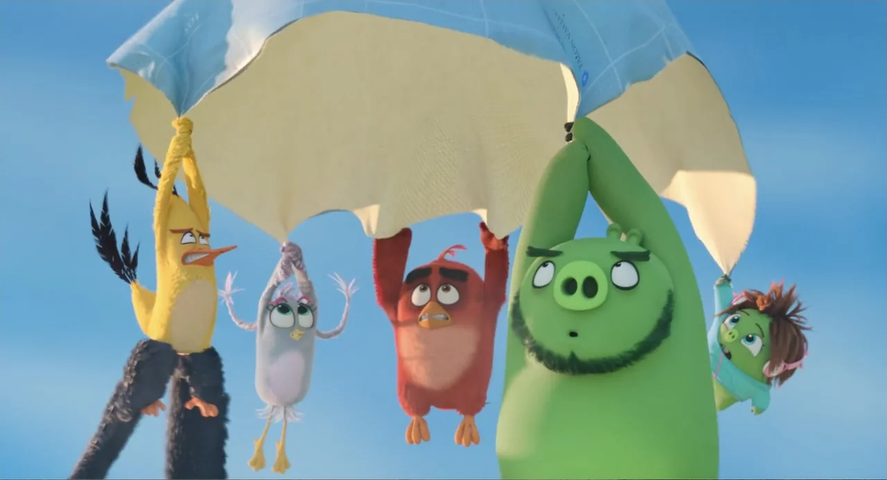 The Angry Birds Movie 2 (2019) movie still: medium — Five cartoon characters hang suspended from a large blue parachute against a bright sky. The…