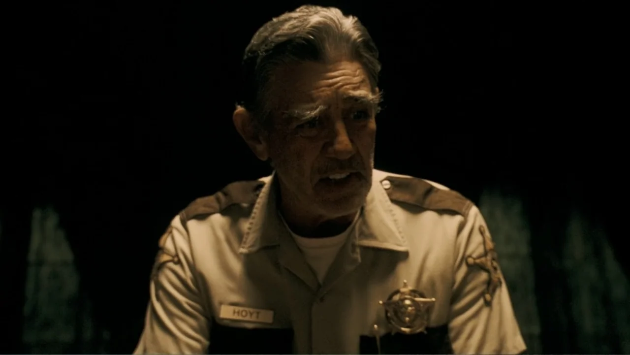 The Texas Chainsaw Massacre: The Beginning (2006) movie still: medium — A dimly lit room with a dark background surrounds the subject. An elderly…