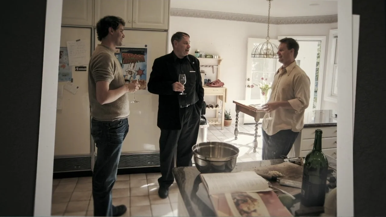 Wild Wild Space (2024) movie still: fullbody — A residential kitchen features white cabinetry, tiled floors, and a center island workspace. Three…