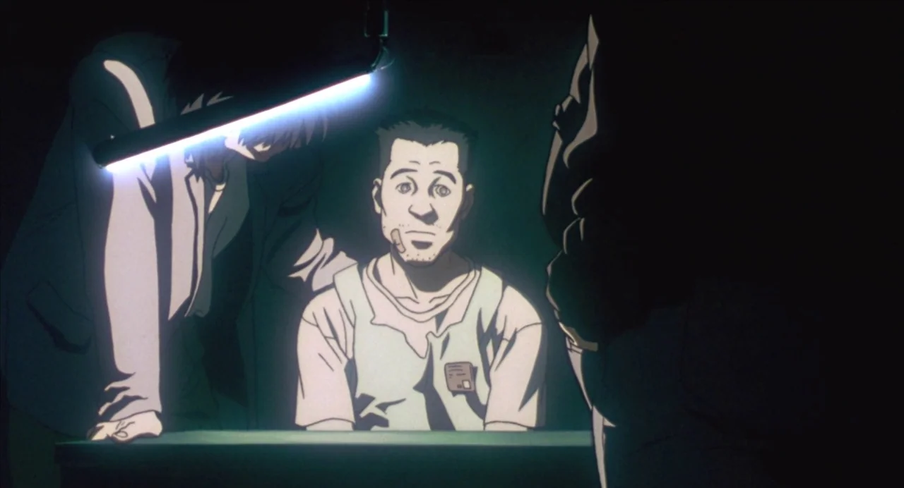 Ghost in the Shell (1995) movie still: medium — An interrogation room features a dark environment with a single hanging fluorescent light fixture. A…