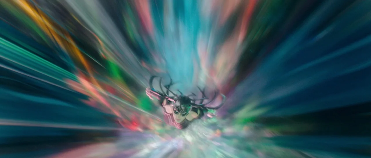 Thor: Ragnarok (2017) movie still: wide — A figure moves through a vibrant, colorful vortex of light streaks in space. The subject wears an…
