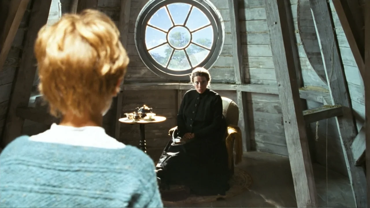 Nanny McPhee and the Big Bang (2010) movie still: medium — An attic room features wooden beams, slanted walls, and a large circular window at back.…