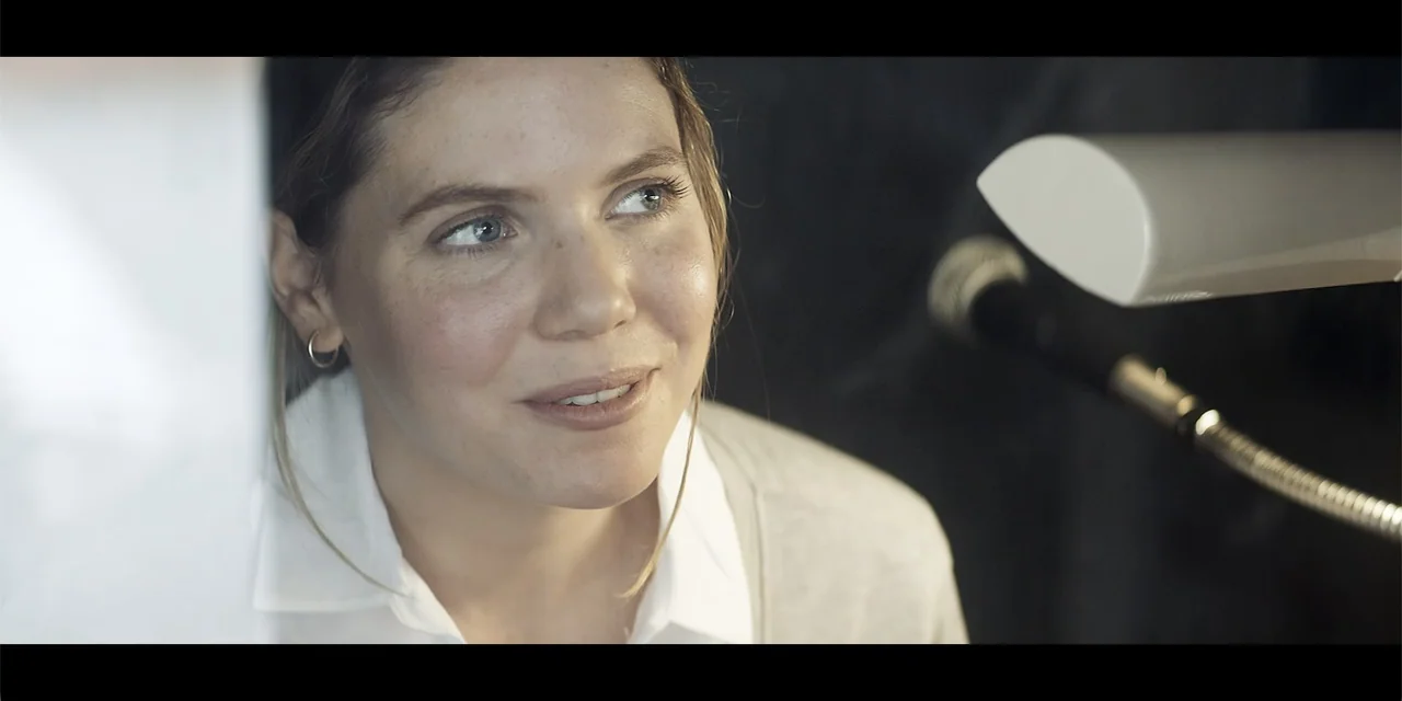 La coda del diavolo (2024) movie still: closeup — A recording studio interior features a microphone positioned near a light-skinned young woman. The…