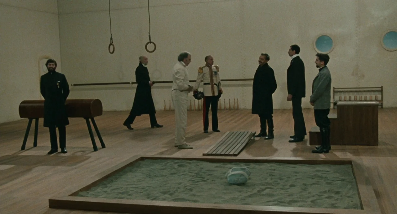 And The Ship Sails On (1983) movie still: wide — A spacious, minimalist wooden training facility features gymnastic equipment and a central sand…
