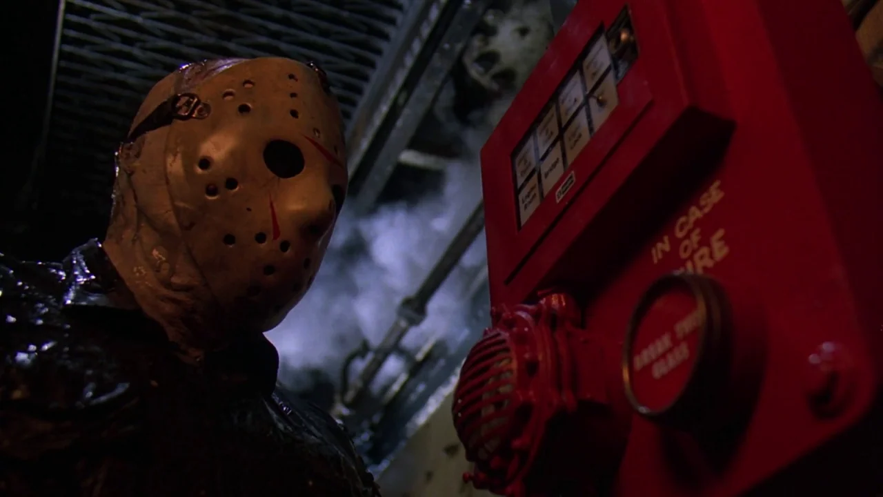 Friday the 13th Part VIII: Jason Takes Manhattan (1989) movie still: medium — A dark industrial corridor features metal grating and metallic pipes…