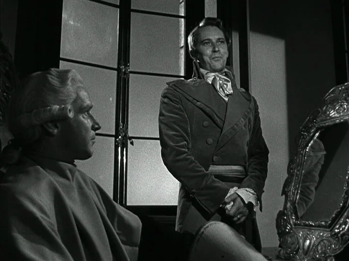 The Black Book (Reign of Terror) (1949) movie still: medium — An interior space with a large window and an ornate silver-framed mirror. A man stands…