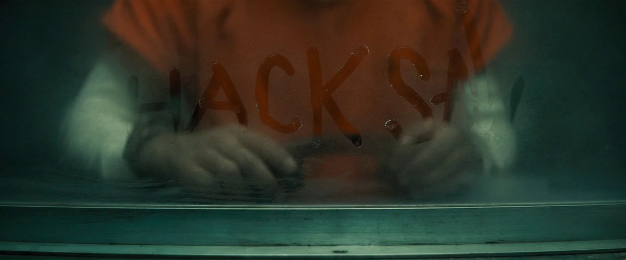 Extremely Wicked, Shockingly Evil and Vile (2019) movie still: medium — A person in an orange jumpsuit sits behind a glass partition in a sterile…