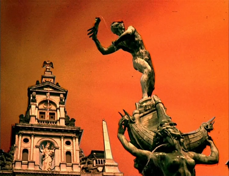The Arrival of Joachim Stiller (1976) movie still: wide — An ornate stone fountain sculpture stands before a classical building with an obelisk.…