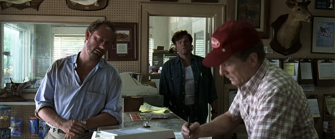 A Family Thing (1996) movie still: medium — A rustic retail counter features pegboard walls decorated with mounted wildlife and framed items. Three…