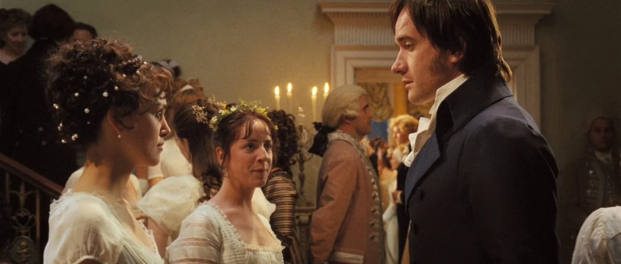 Pride & Prejudice (2005) movie still: medium — A 19th-century society event takes place within an elegant cream-colored room with candlesticks. A…