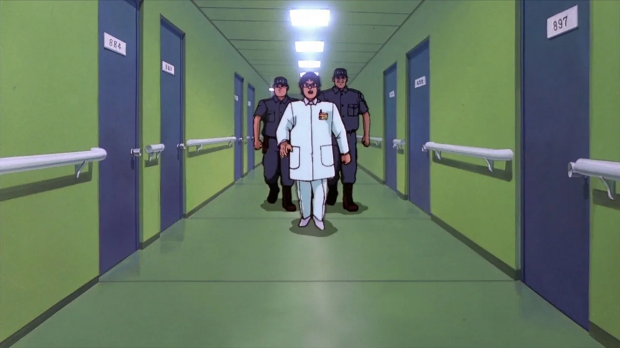 Akira (1988) movie still: fullbody — A long, institutional corridor features lime green walls and dark blue numbered doors. A man in a lab coat…