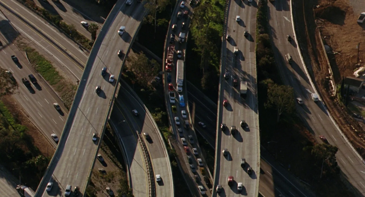 House of Wax (2005) movie still: establishing — An aerial view of a complex highway interchange with multiple concrete overpasses crossing paths.…