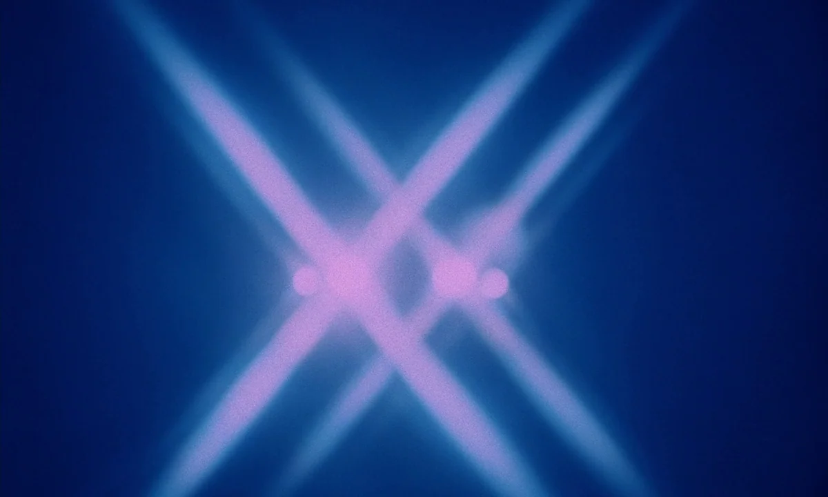 Daughters of Darkness (1971) movie still: establishing — An abstract dark space features intersecting beams of purple light against a blue…
