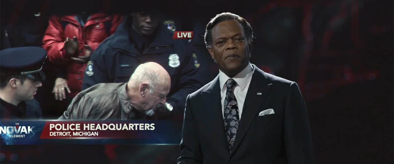 RoboCop (1987) movie still: medium — A studio set with dark background and overlaid digital news graphics showing police activity. An older man in a…