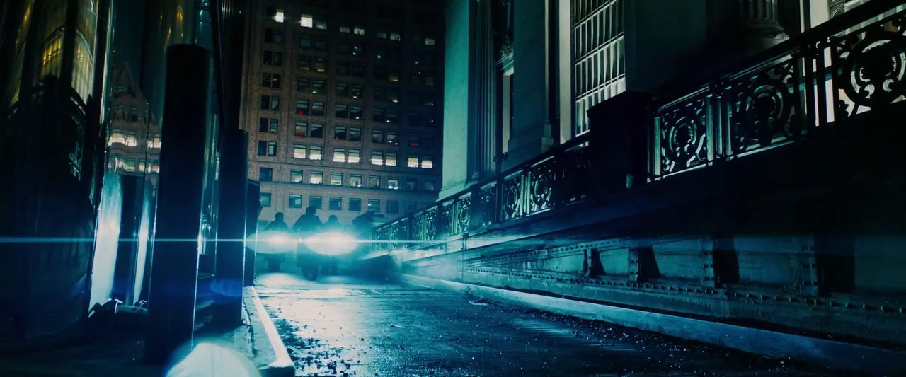 John Wick: Chapter 3 – Parabellum (2019) movie still: wide — A dark city street at night features a stone railing beside a tall building. Intense…