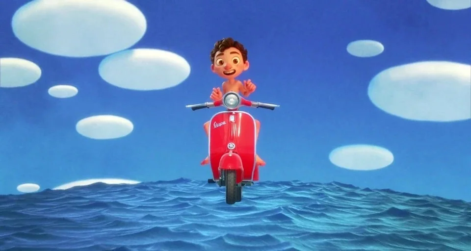 Luca (2021) movie still: medium — A surreal blue seascape with rounded white floating shapes against a clear blue sky. A shirtless boy rides a…